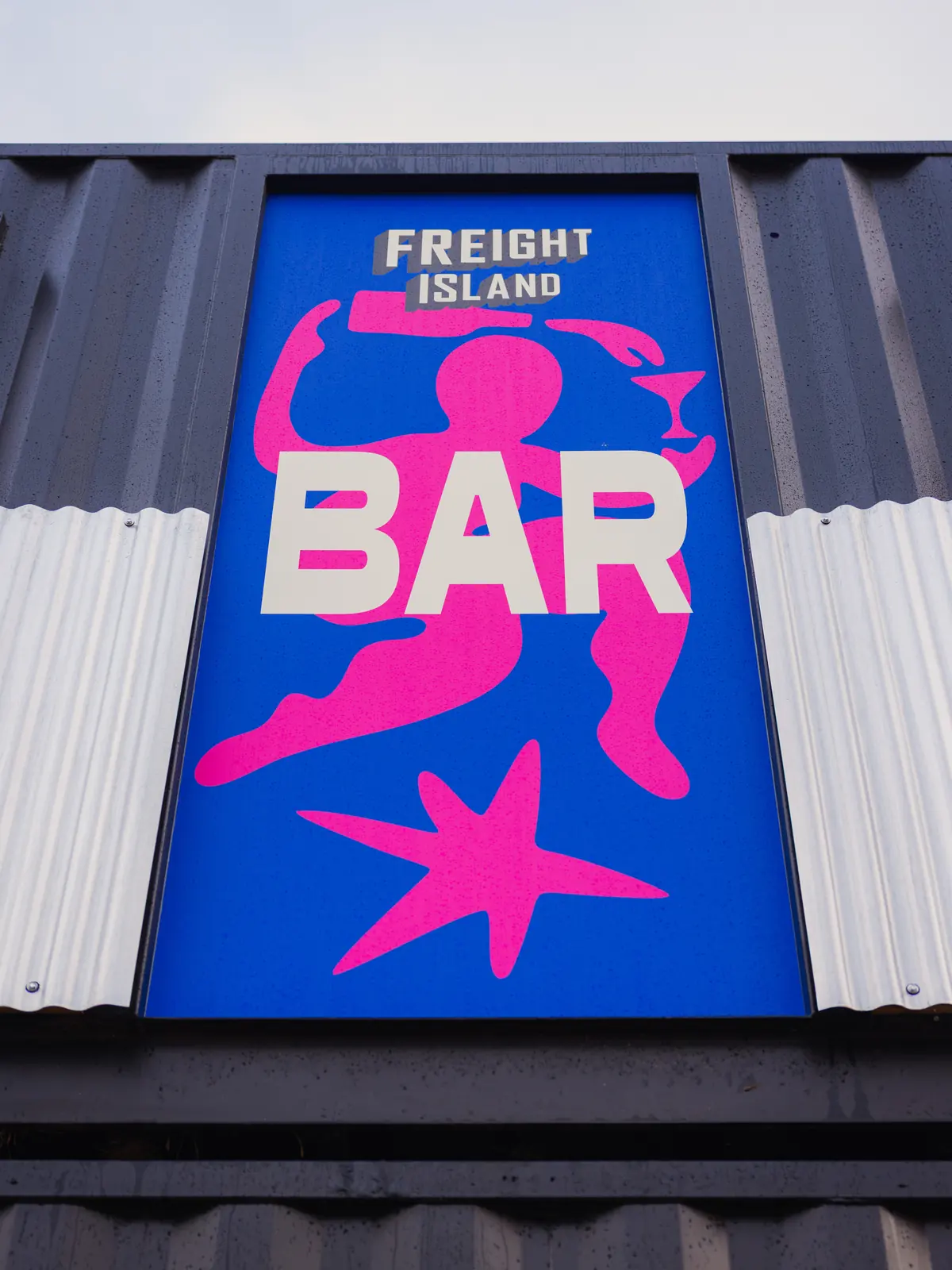 Brightly painted bar sign on a shipping container