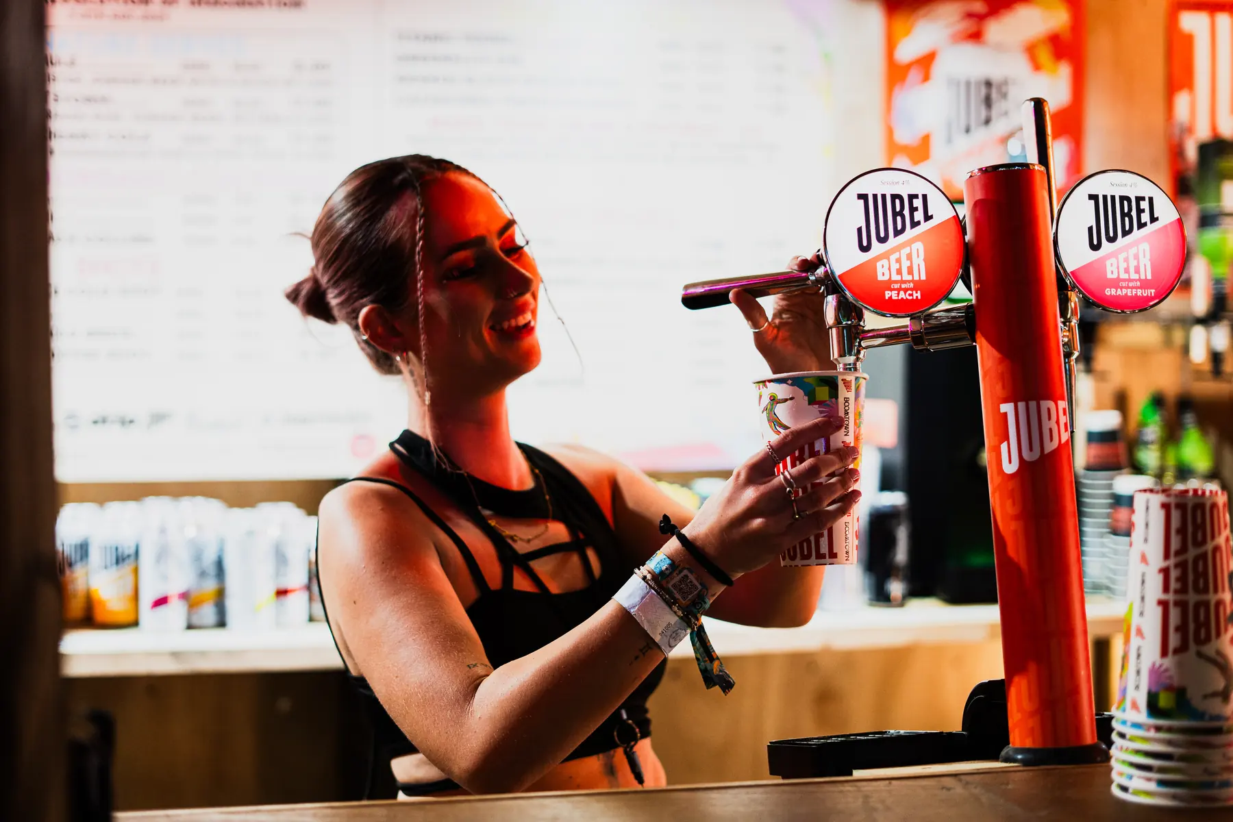 Bartender pouring draught Jubel into a branded festival cup