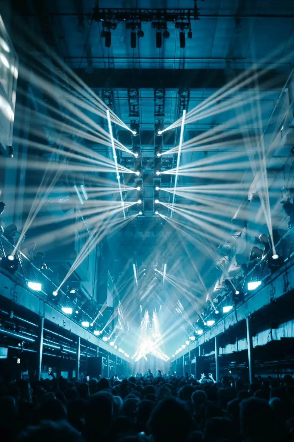 Packed venue with lighting rig and beams over the crowd